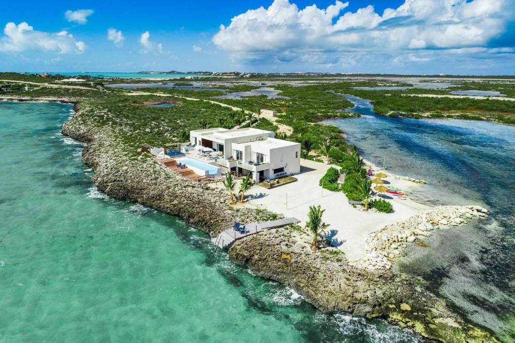 una vista aérea de un complejo en una isla rocosa en el océano en Luxury Oceanfront Villa Delivers Mind Blowing Views, Direct Access To The Ocean, en Providenciales