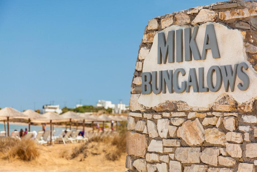 a sign for a hotel on the beach at Mika Bungalows in Naousa