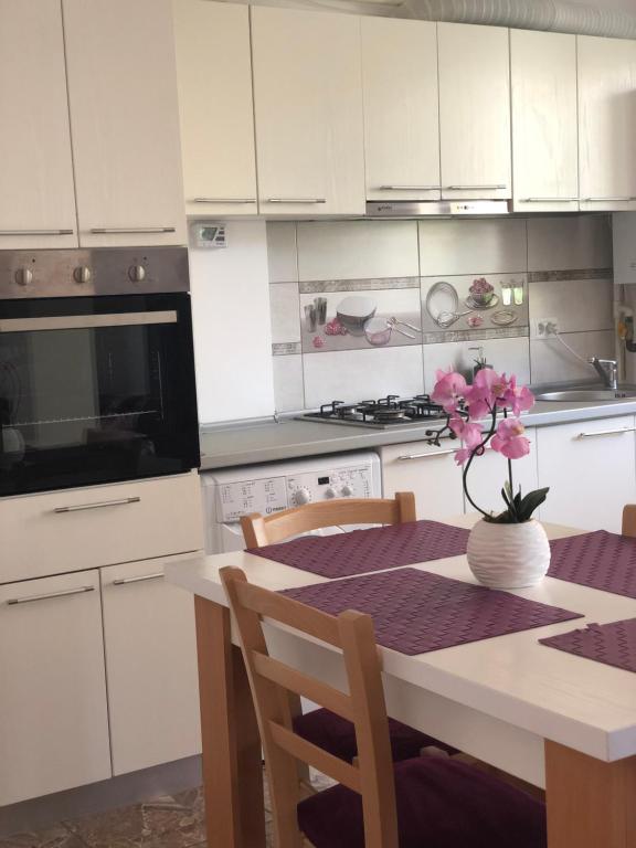 eine Küche mit einem Tisch und einer Blumenvase darauf in der Unterkunft Apartamente Seashells Mamaia Nord in Mamaia Nord – Năvodari