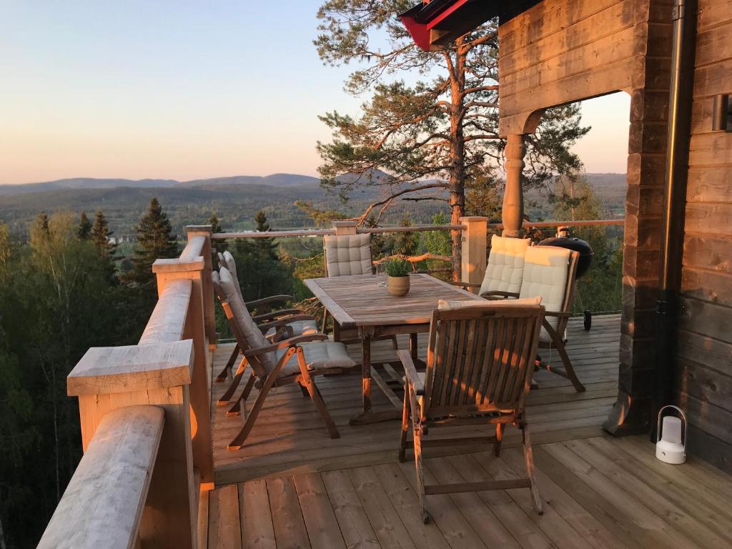 une terrasse en bois avec une table et des chaises dans une cabine dans l'établissement Alpstigen 10A - Newly built sports lodge with amazing views, à Järvsö