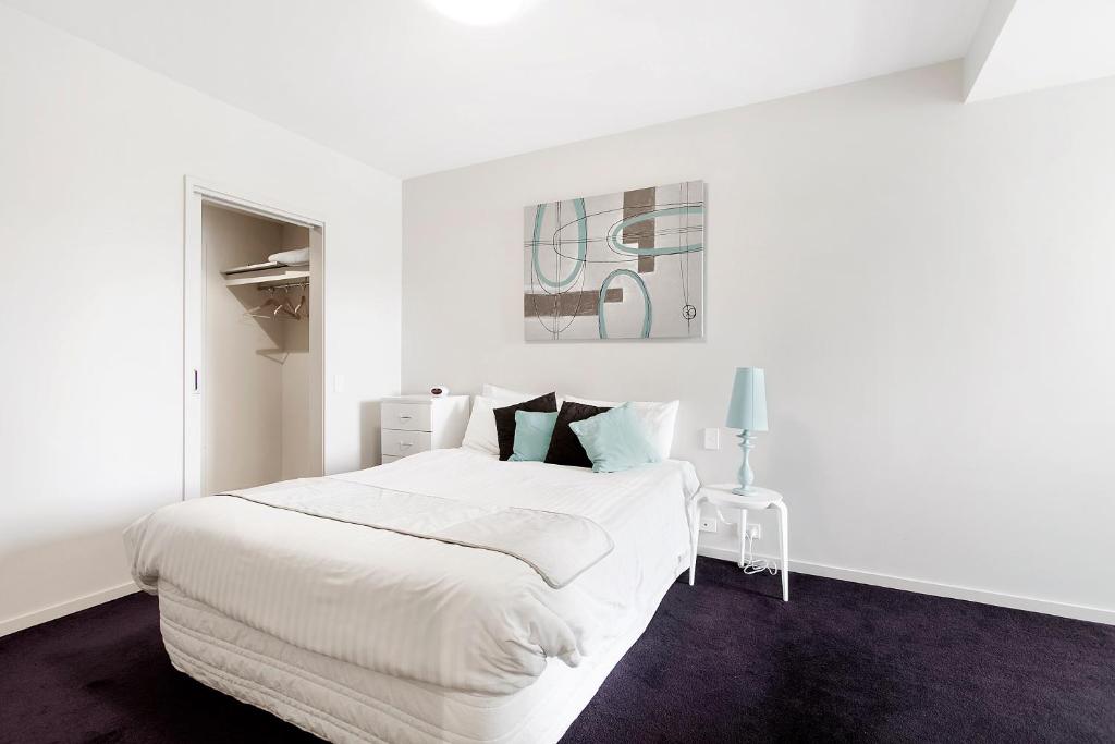 a white bedroom with a large white bed in it at Docklands Private Collection - NEWQUAY in Melbourne