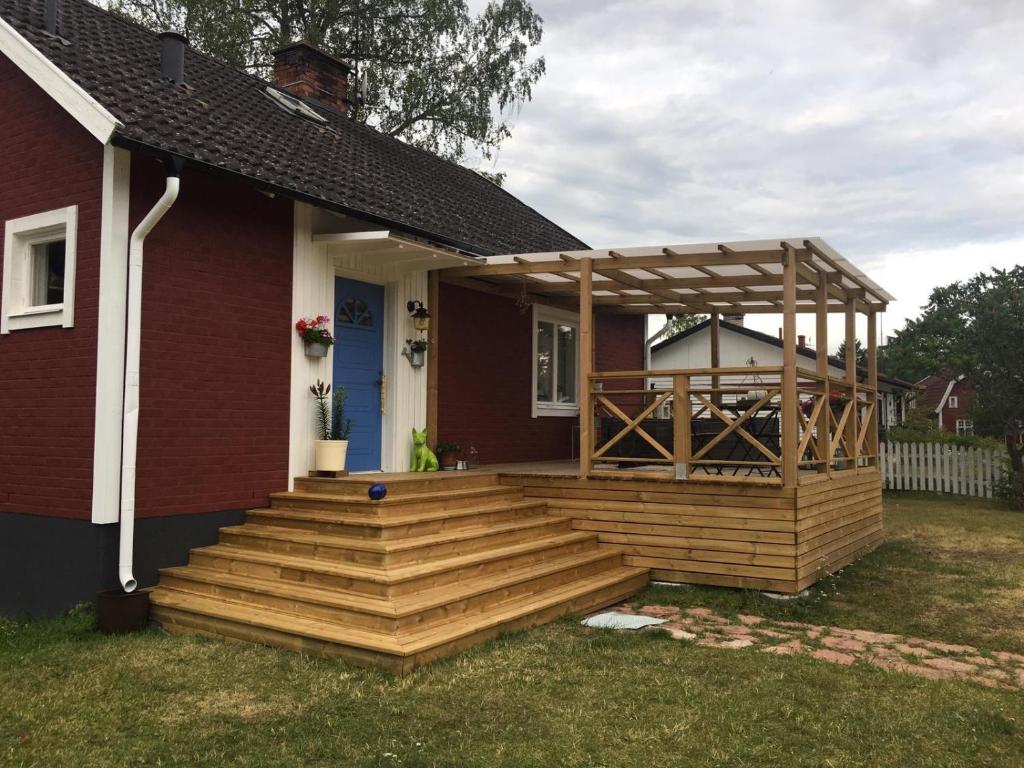a wooden deck with a pergola on a house at Kolstigenhus in Fågelfors