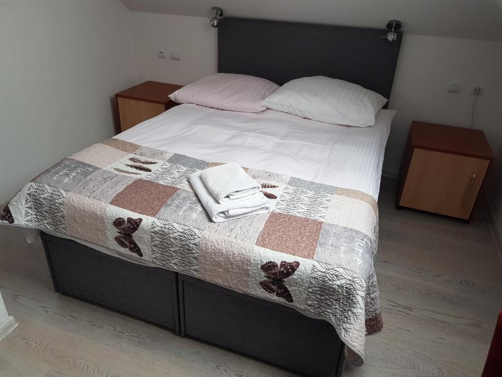 Una cama con edredón y dos toallas. en Gościniec Słoneczny en Drzonków