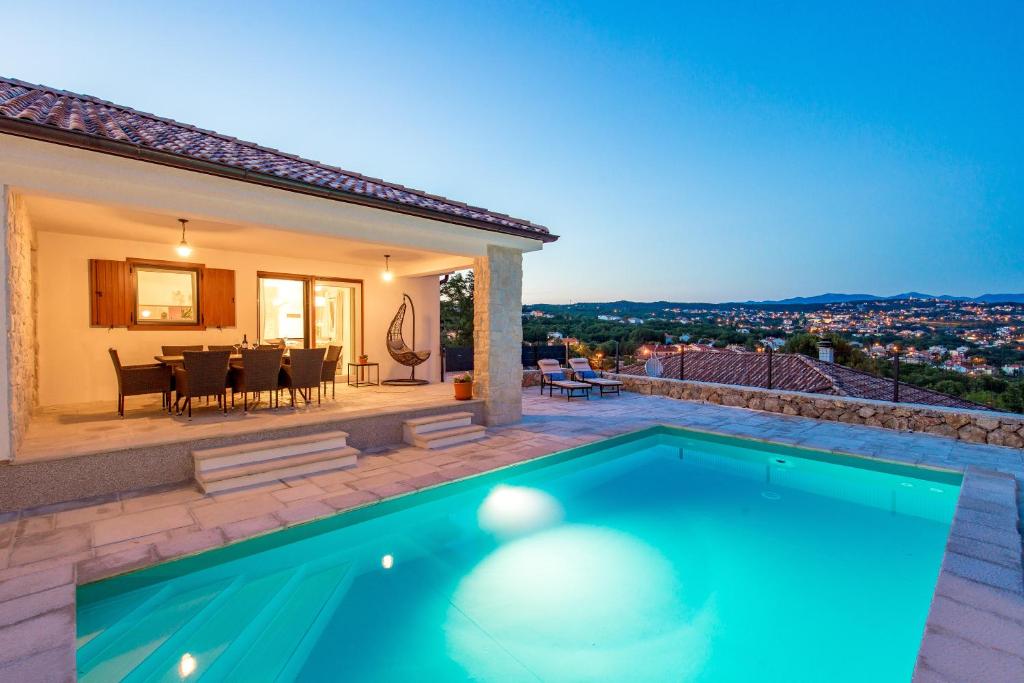 a villa with a swimming pool in front of a house at Apartment Niki in Opatija