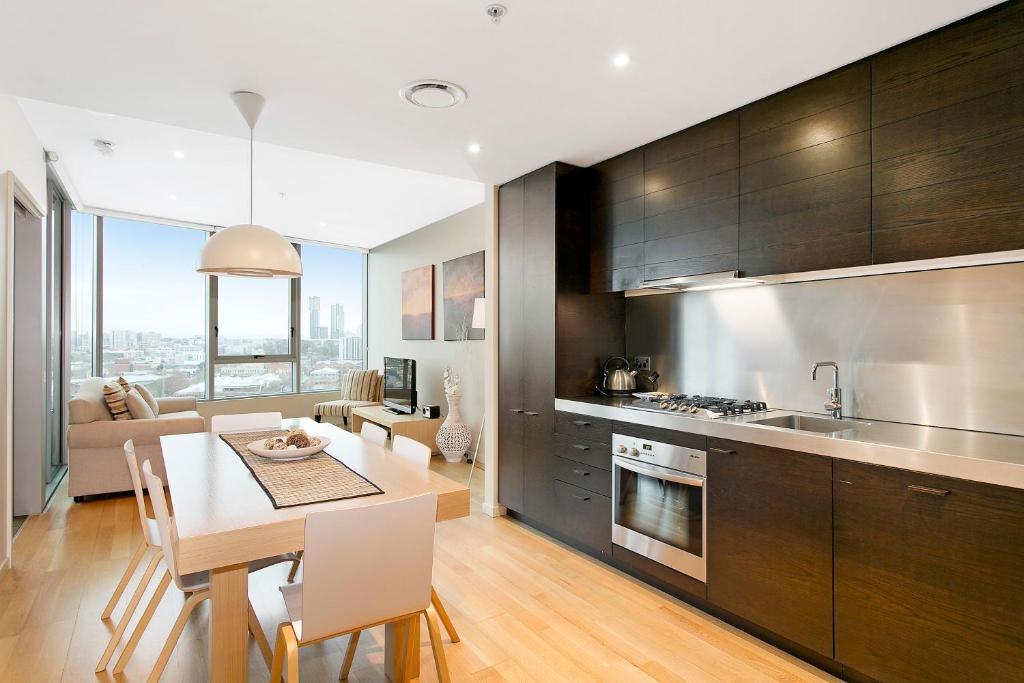 a kitchen with a table and a dining room at Docklands Private Collection - NEWQUAY in Melbourne