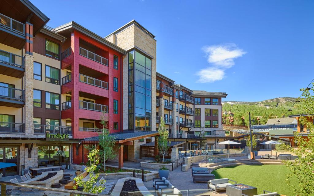 a group of buildings with a park in front at Limelight Hotel Snowmass in Snowmass Village