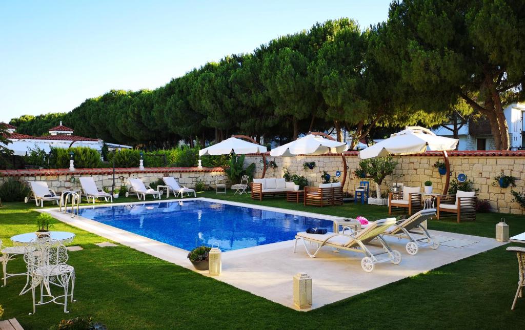 a swimming pool with lounge chairs and a table at Salbakos Herakleia Boutique Hotel in Alacati