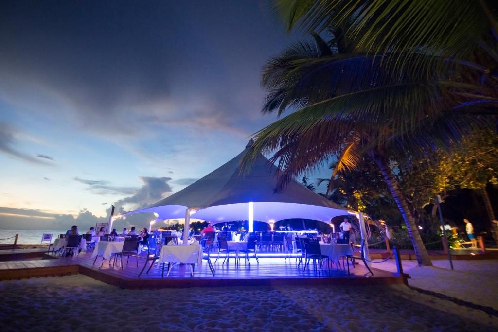 un tendone sulla spiaggia di notte con tavoli e sedie di Viva Dominicus Palace by Wyndham, A Trademark All Inclusive a Bayahibe