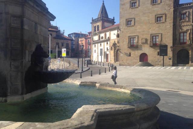 una persona caminando por una fuente en una ciudad en Vicaria, en Gijón