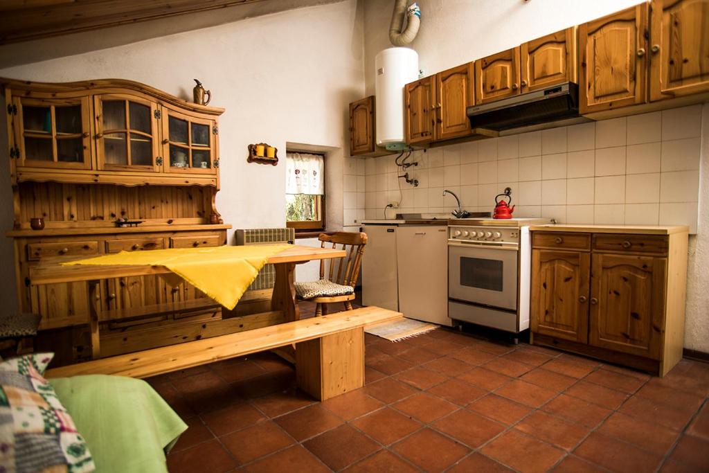 a kitchen with wooden cabinets and a table in it at Attico vintage Roccaraso in Roccaraso