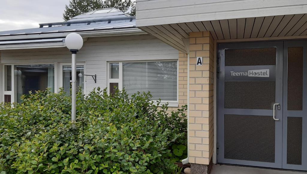 une porte d'entrée d'une maison munie d'un panneau. dans l'établissement Teemahostel, à Toivakka