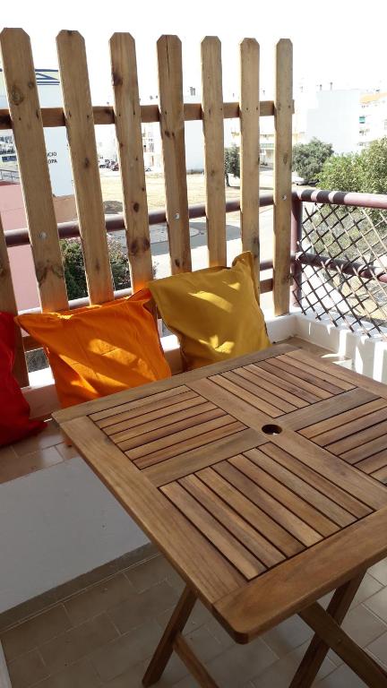 a wooden bench sitting on top of a balcony at Vista Real in Vila Nova De Cacela