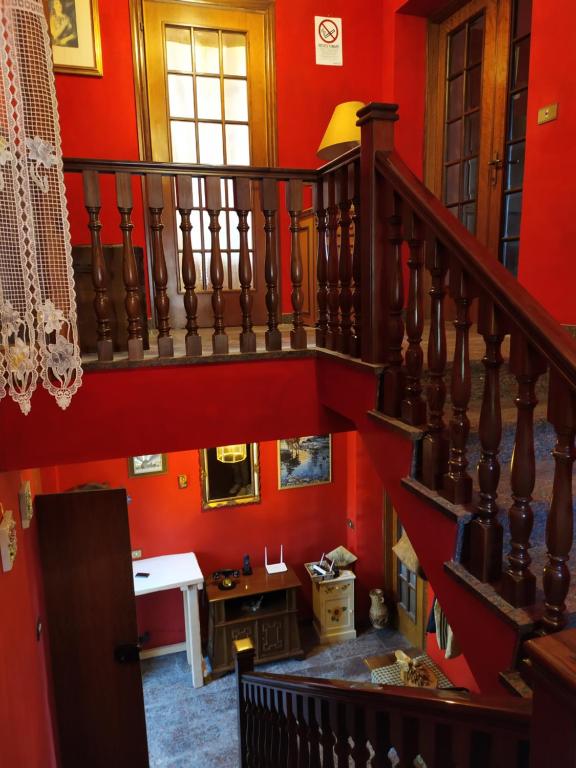 een trap in een kamer met rode muren bij AFFITTACAMERE MINA in Sigillo
