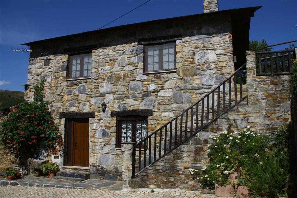 a stone house with a staircase on the side of it at Ninho do Melro - Turismo Rural Bragança in Bragança