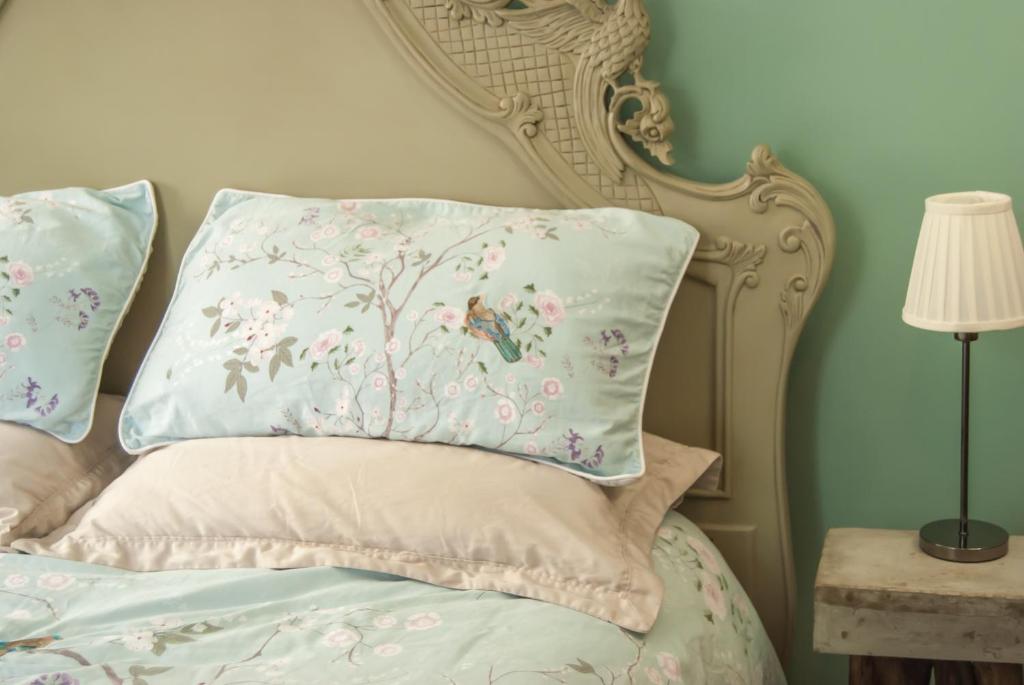 a bedroom with a bed with a floral pillow at The Broken Dish - Full Cottage Apartment in Mendham