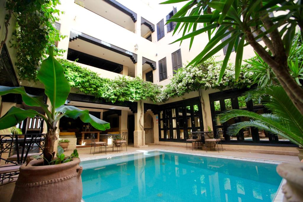 a swimming pool in front of a building with plants at Riad Dar Haven in Tamraght Oufella