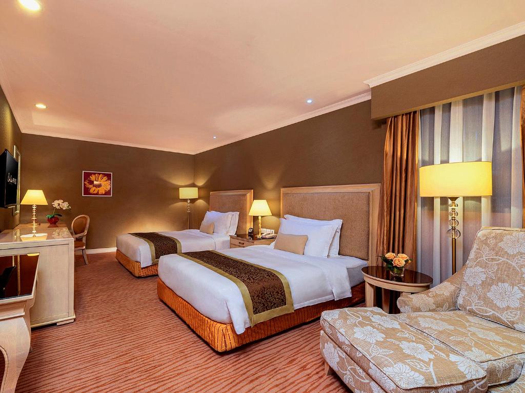 una camera d'albergo con due letti e un divano di Similan Hotel Zhuhai-Gongbei Port a Zhuhai