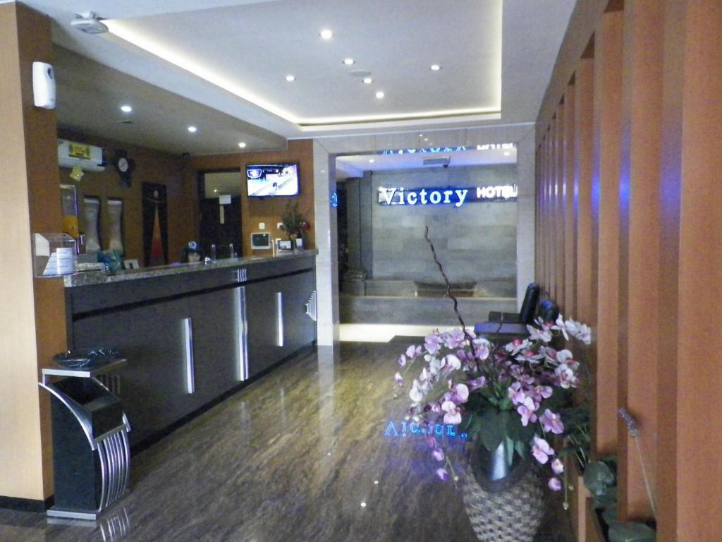a hospital lobby with a reception counter and flowers at Hotel Victory Bandung in Bandung