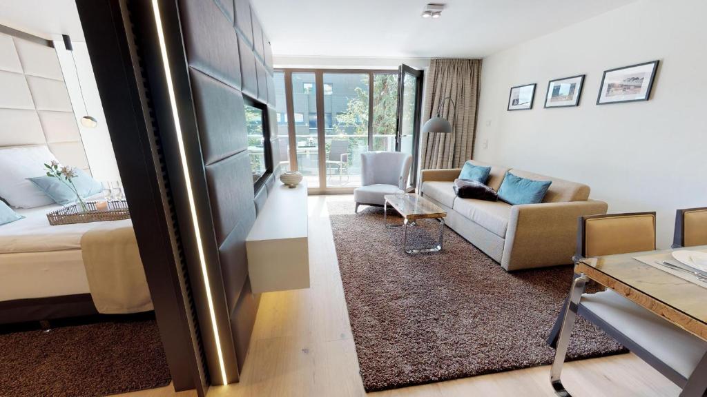 - un salon avec un lit et un canapé dans l'établissement White Pearl Apartment 2.04, à Timmendorfer Strand