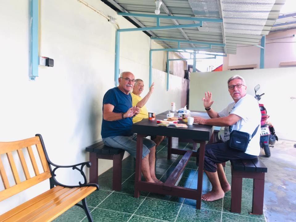 a group of three men sitting at a table at Best Rent a Room in Nai Yang Beach