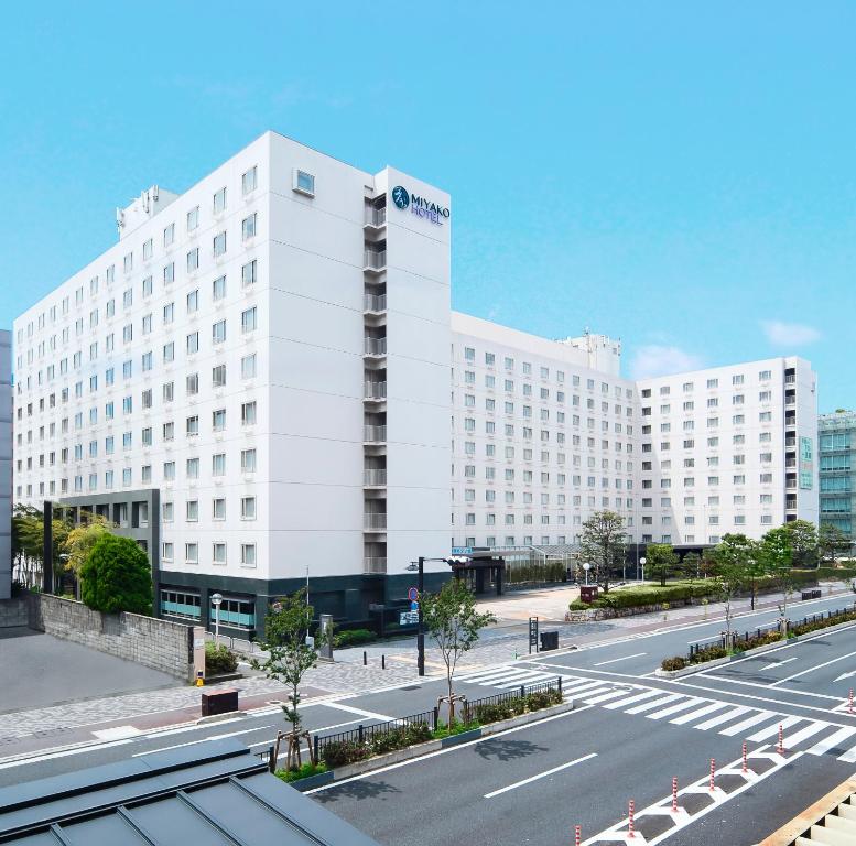 a large white building on a city street at Miyako Hotel Kyoto Hachijo in Kyoto