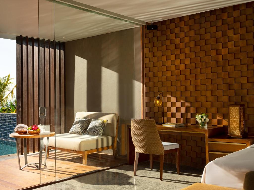 a room with a bed and a table and a chair at Anantara Uluwatu Bali Resort in Uluwatu