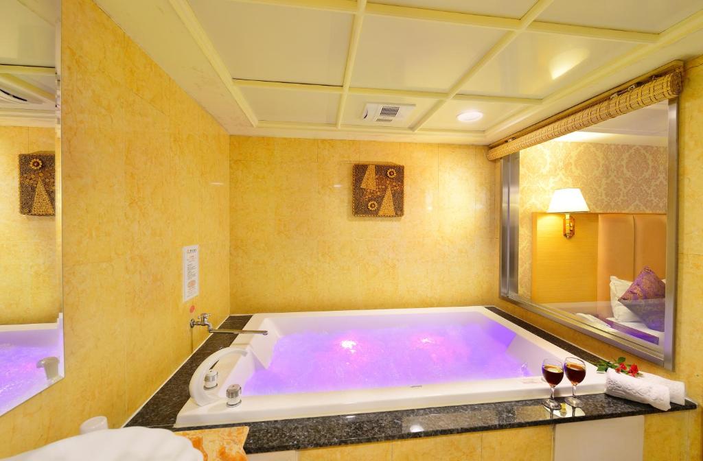 a bath room with a tub and a sink at Chyuan Du Spring Resort in Taipei