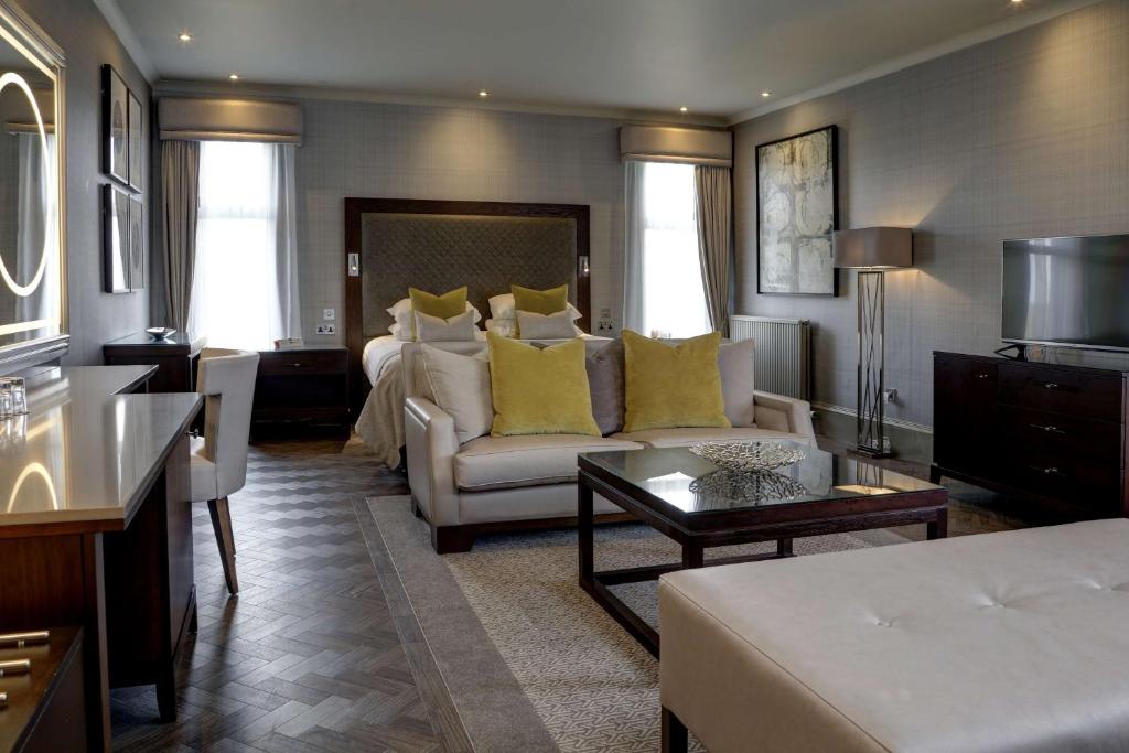 Best Western Garfield House Hotel في Chryston: غرفة معيشة كبيرة مع سرير وأريكة