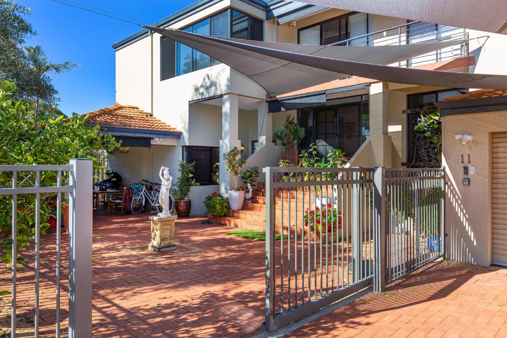 a house with a gate and a fence at Como Executive Apartment in Perth