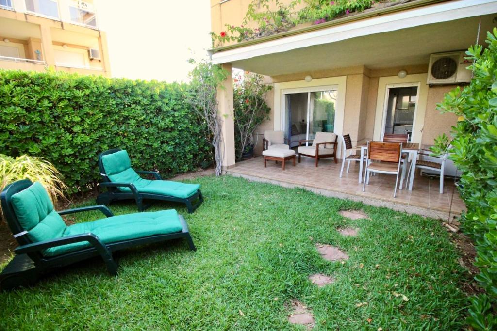 einen Garten mit Stühlen und Tischen sowie eine Terrasse in der Unterkunft La Rosaleda 71 in Denia