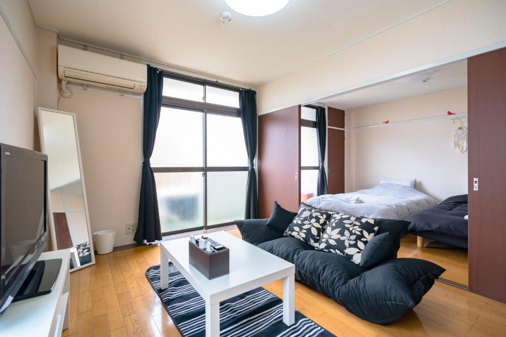 uma sala de estar com um sofá e uma cama em Murata Corpo 301 em Tóquio