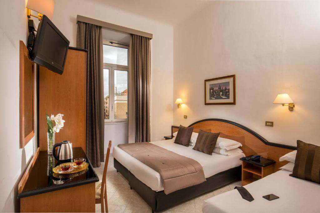 a hotel room with two beds and a television at Hotel Sonya in Rome