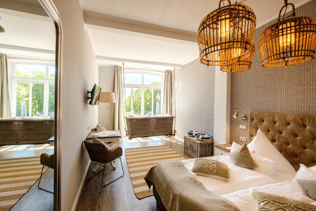 a bedroom with a bed and two chandeliers at Das 53°Hotel in Bad Zwischenahn