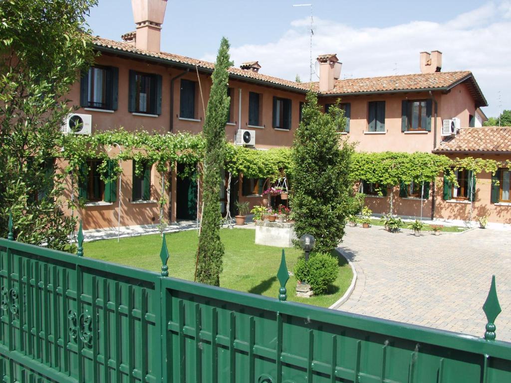 a green fence in front of a building with a courtyard at Dreon B&B in Portogruaro
