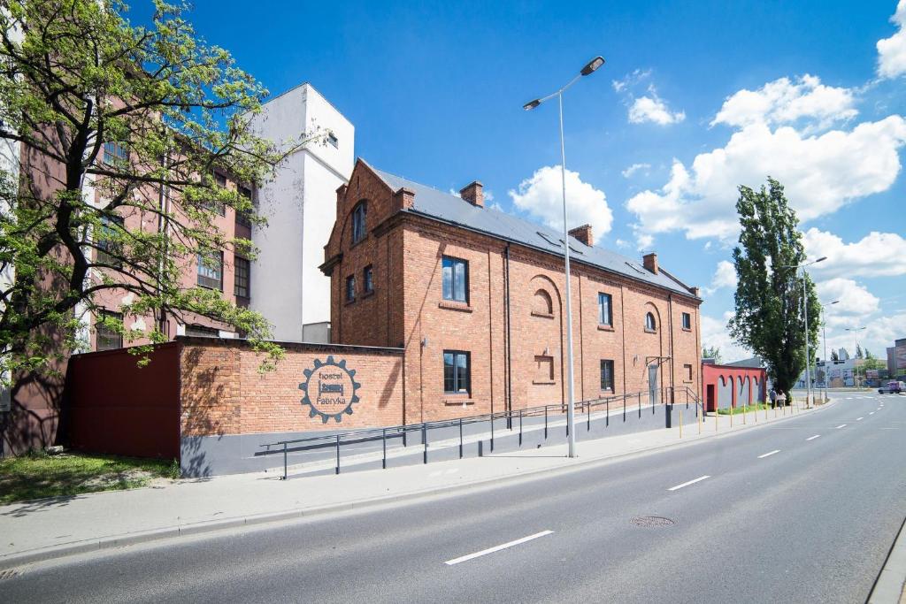 a brick building on the side of a road at Hostel Fabryka in Włocławek