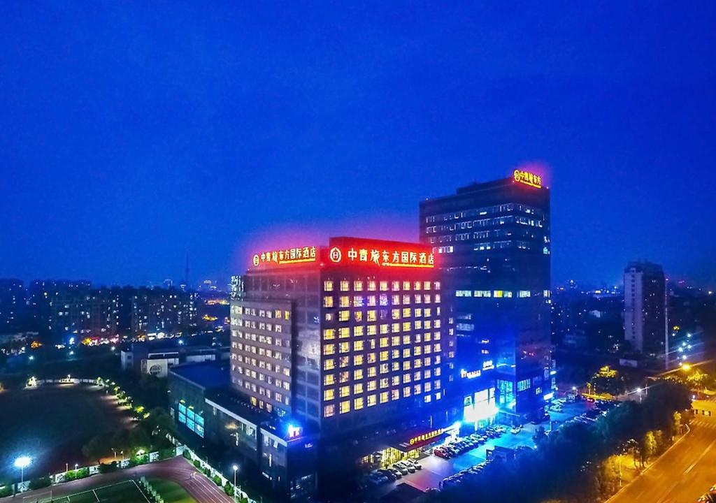 un edificio alto con luci rosse e blu sopra di CYTS Eastern Jiading Hotel Shanghai - Original CYTS GreenTree Eastern International Hotel a Jiading