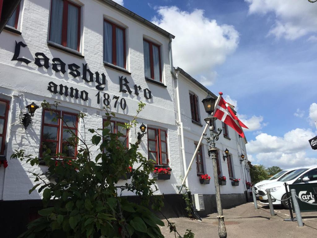 een gebouw met een vlag ervoor bij Hotel Laasby Kro in Låsby