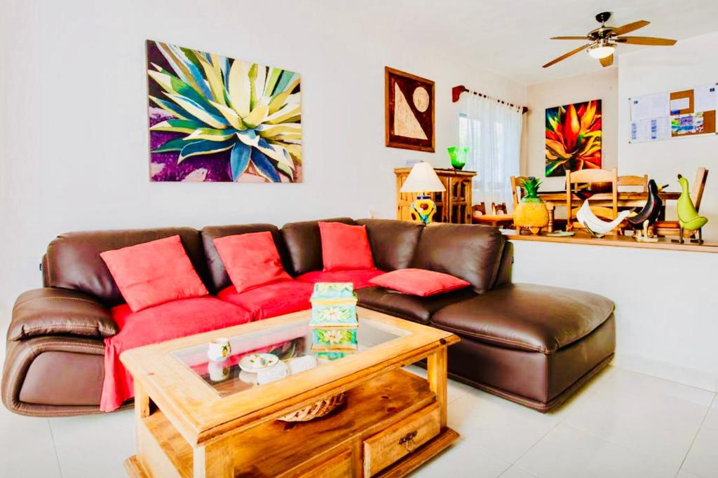 a living room with a brown couch and a coffee table at Deluxe Family Comfort Balcony Room with Pool Playacar Ii in Playa del Carmen