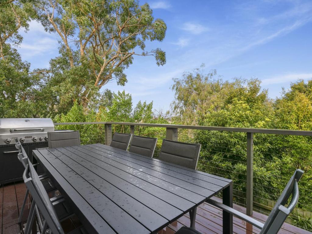 a wooden table on a deck with a grill at SUMMER BREEZE FREE WIFI & NETFLIX INLET SIDE CENTRAL LOCATION in Inverloch