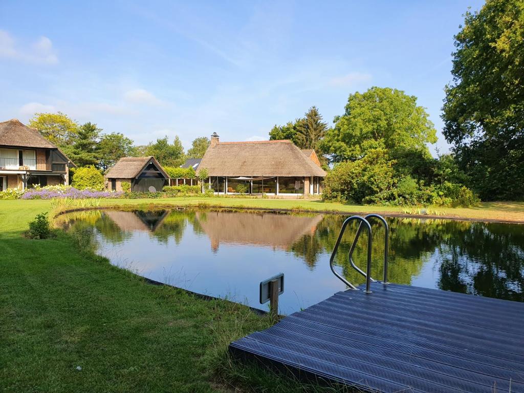 a small pond with a house in the background at Schaluinenhoeve in Baarle-Nassau