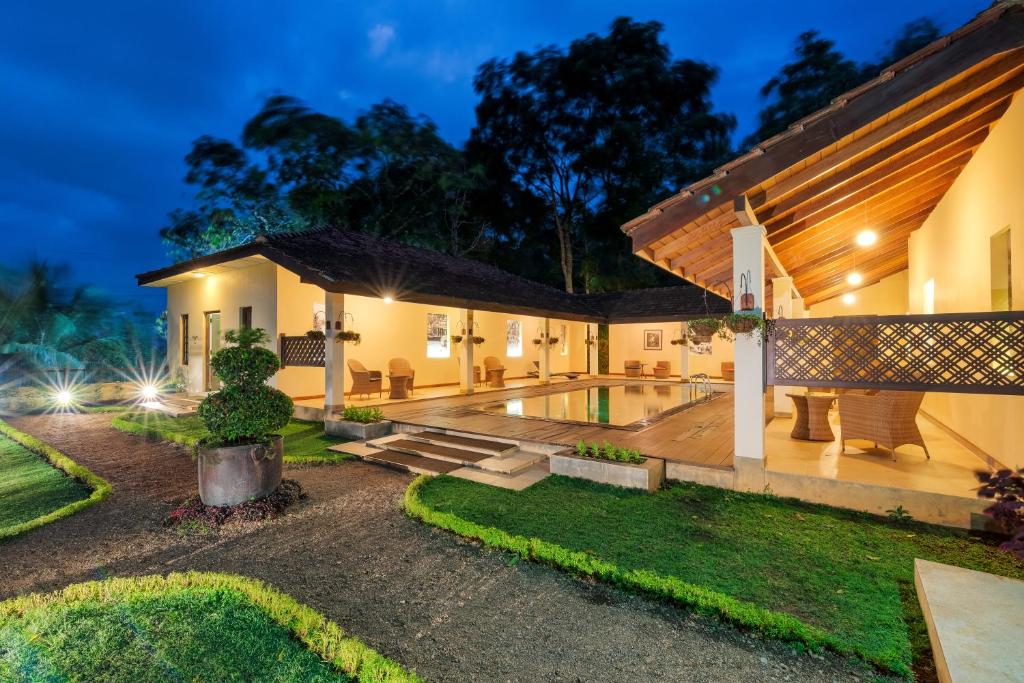 una casa con piscina por la noche en Hanthana Boutique Villa by Amaya, en Kandy