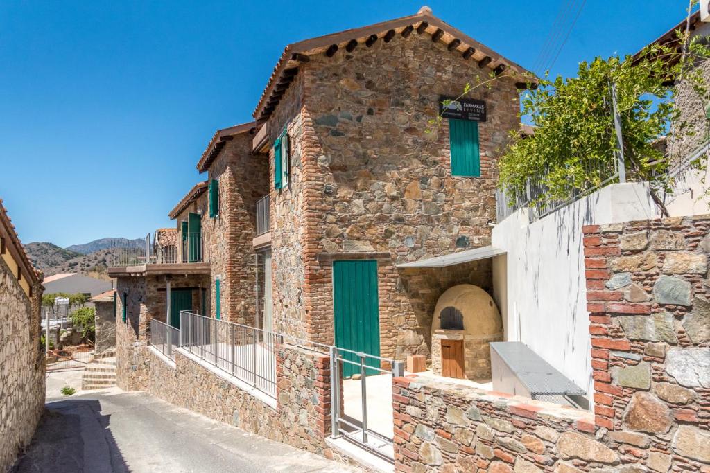 a stone house with green doors on a street at Farmakas Living in Farmakas