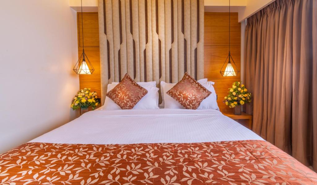 a bedroom with a large bed with pillows at Hotel Metropole Inn in Mumbai