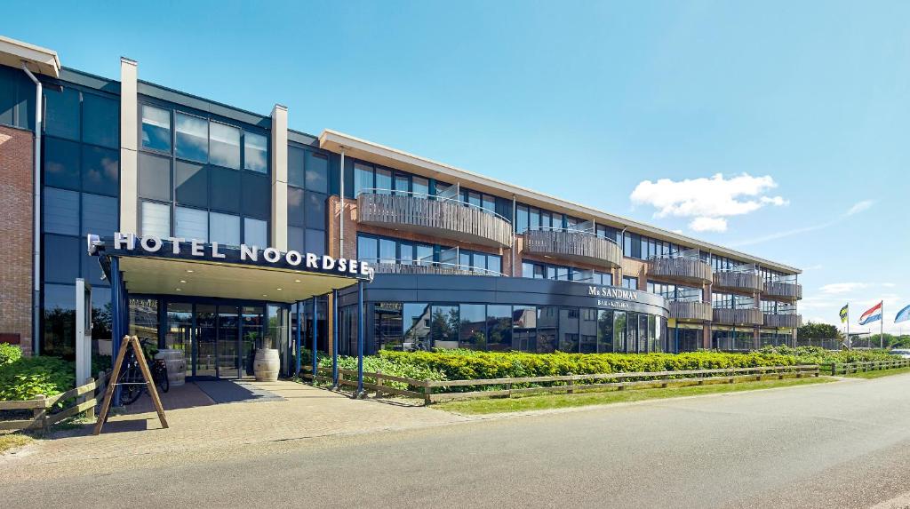 ein Gebäude mit einem hoteleigenen Noordhopper davor in der Unterkunft WestCord Hotel Noordsee in Nes