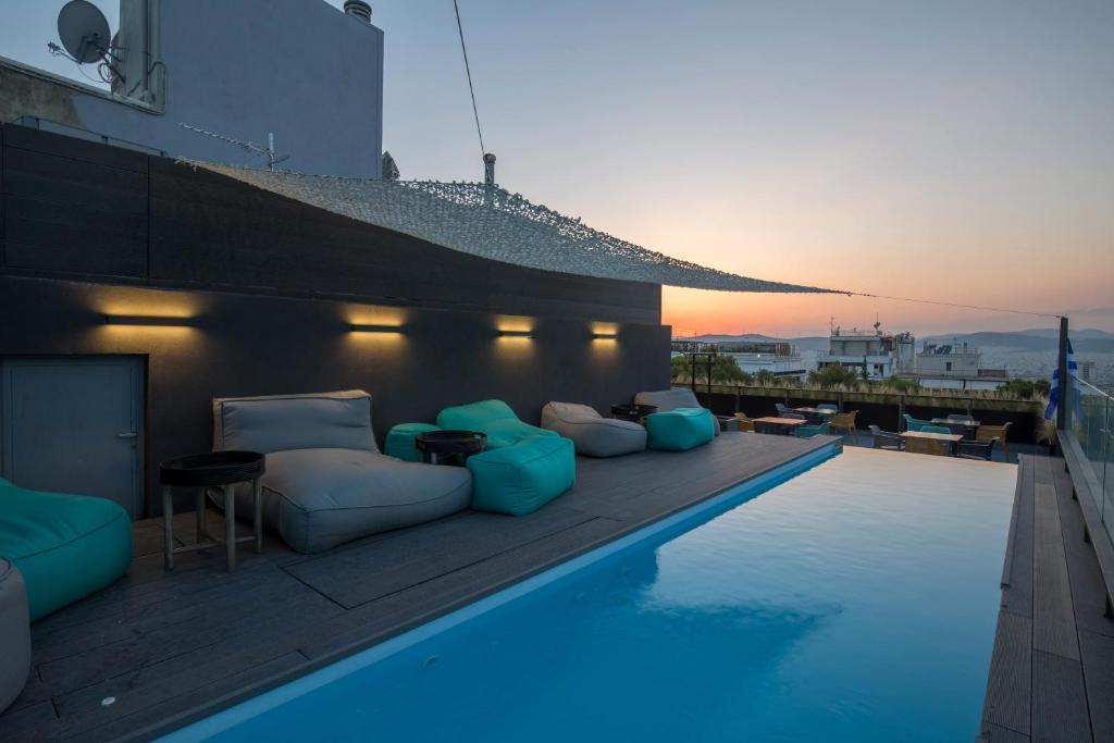 a pool with chairs and tables on the side of a building at The Duke Boutique Suites in Athens