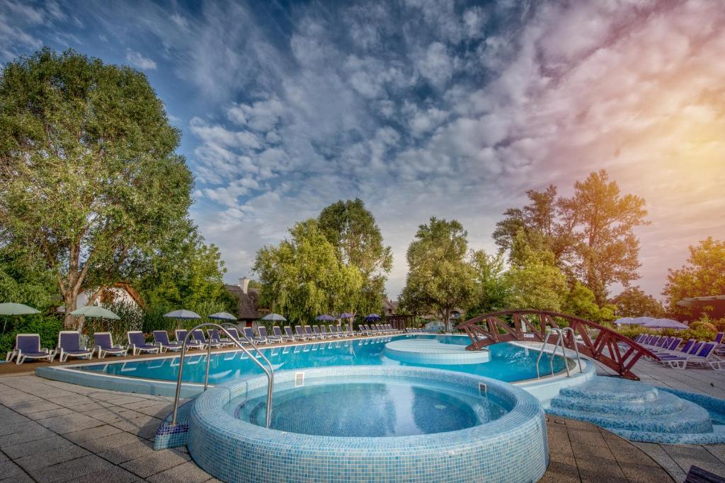 una gran piscina con un puente y sillas en Club Dobogómajor superior, en Cserszegtomaj