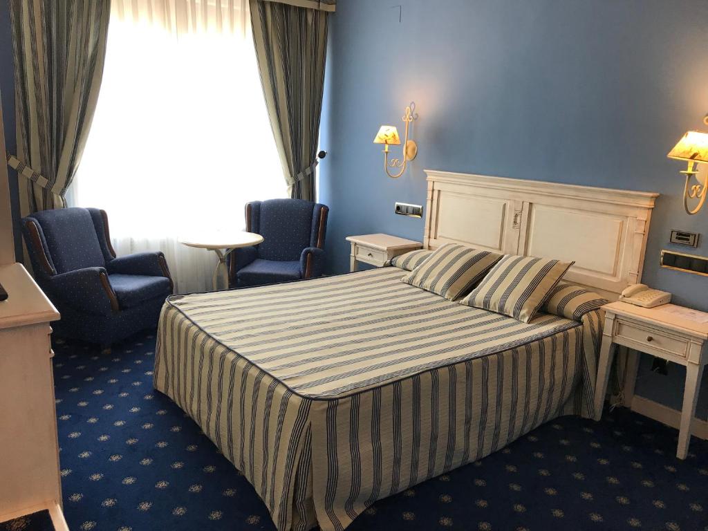 En eller flere senger på et rom på Hotel Leonor Mirón