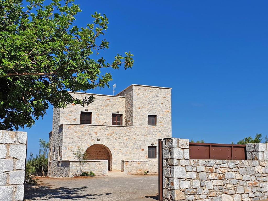 un edificio de ladrillo con una puerta y una pared de piedra en Anaroussa Diros Maisonette, en Areopoli