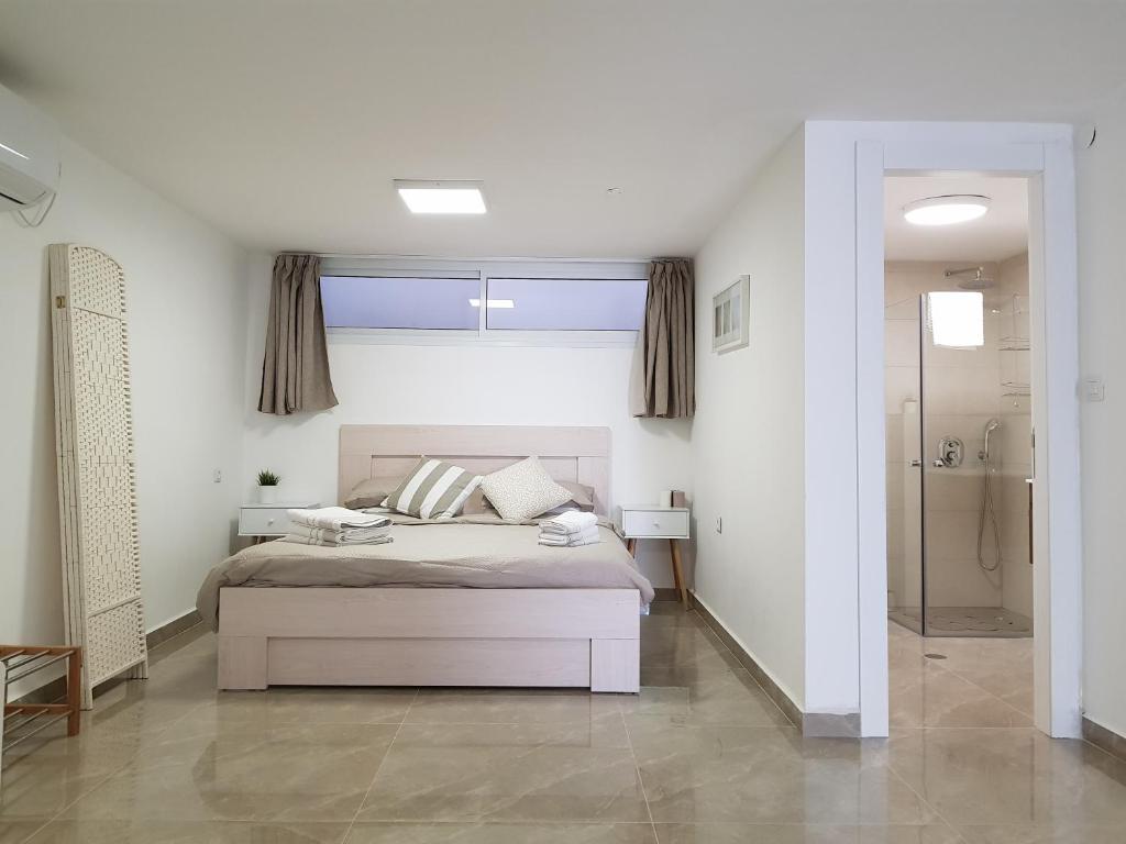 een slaapkamer met een bed en een inloopdouche bij Eleni apartment Eilat in Eilat