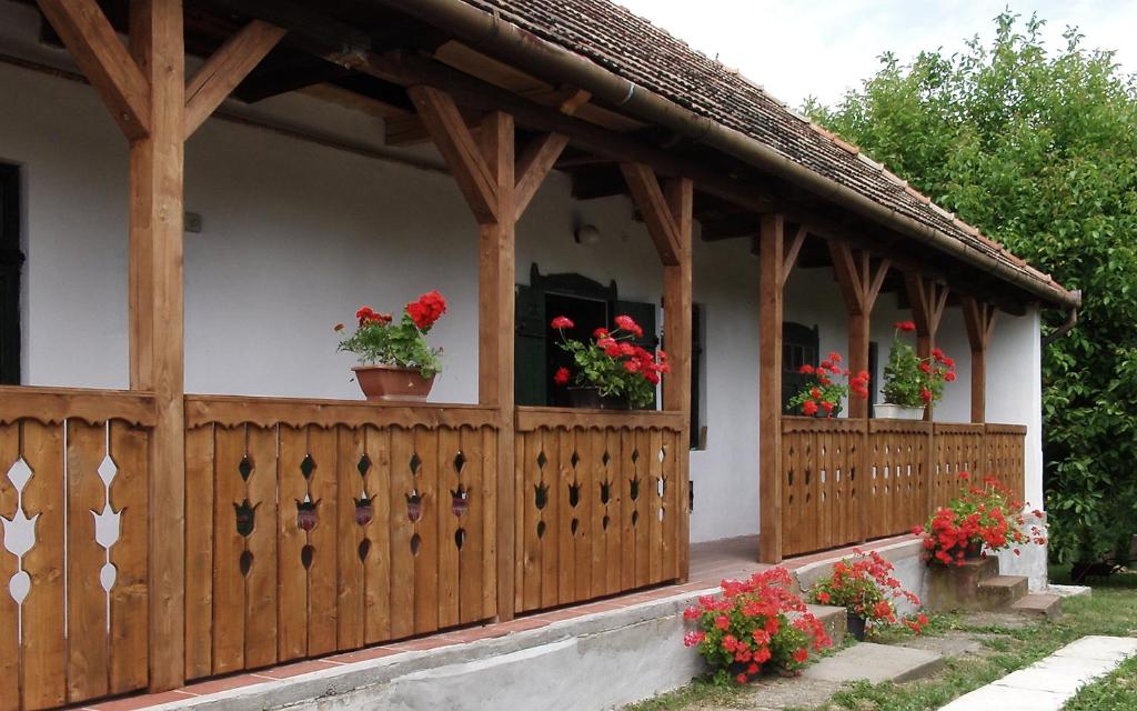 een houten hek met potbloemen op een huis bij Nevenincs Vendégház in Bátor